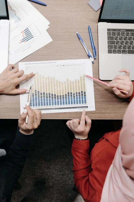 Une équipe variée travaillant ensemble sur des stratégies de marketing numérique autour d’une table, avec des ordinateurs portables et des tablettes.
